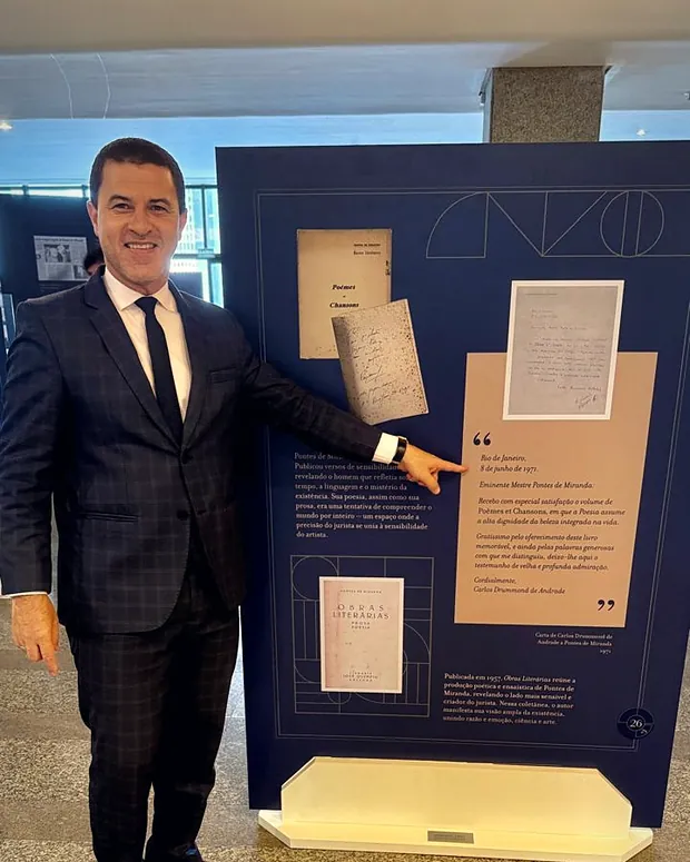 Dr. Márcio Lima da Silva diante de um painel da exposição Acórdãos, em Brasília.